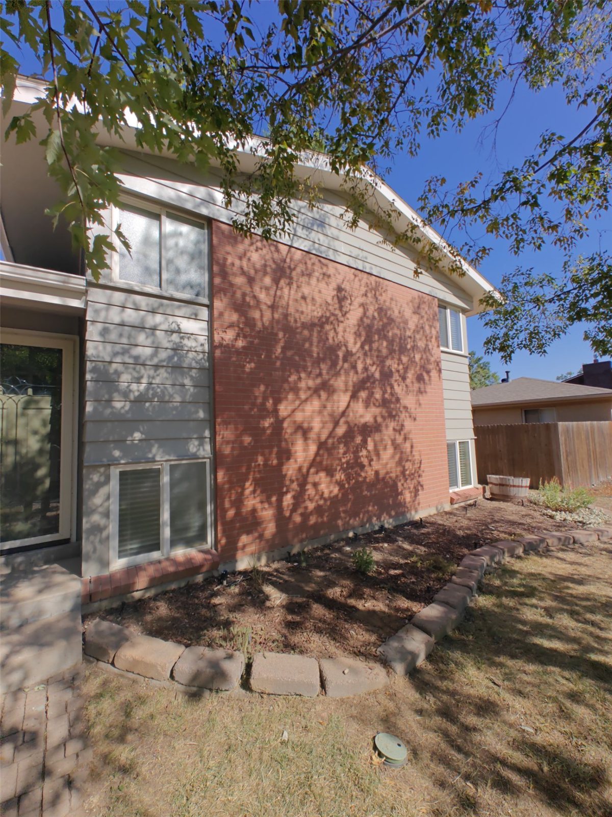 After: repainted bay window corner with brick and siding, Arvada, Colorado
