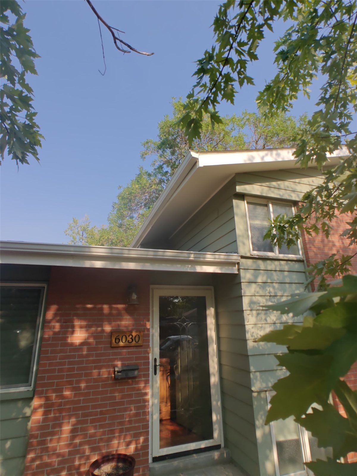 Before: front entry of the Arvada home with faded sage-green siding