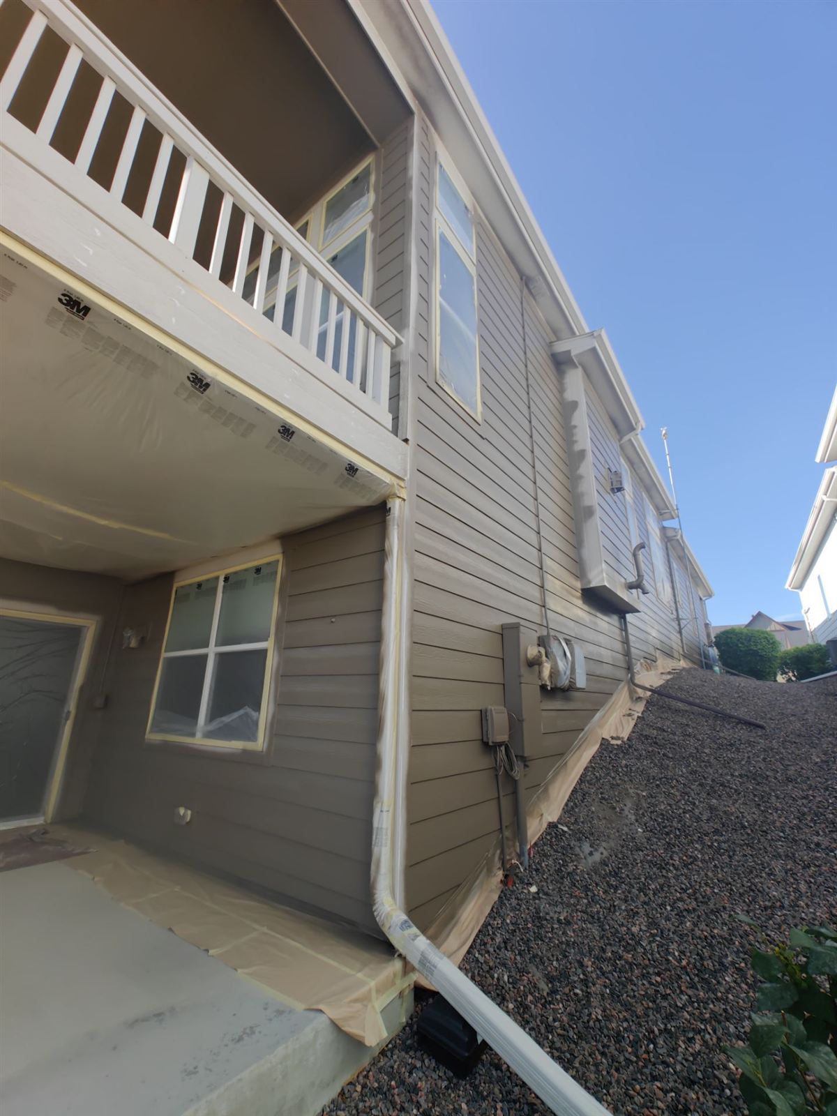 Painter masking and prepping a home exterior before painting in Arvada, Colorado
